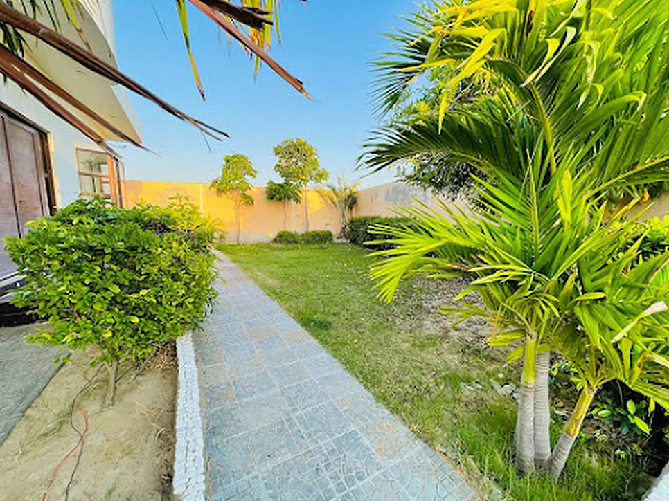 Green lawn and outdoor seating at Agha Farmhouse