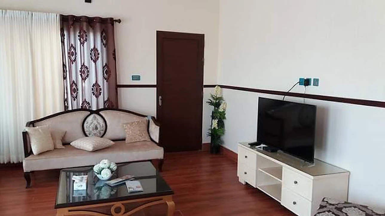 Comfortable lounge with sofas and TV at Agha Farmhouse
